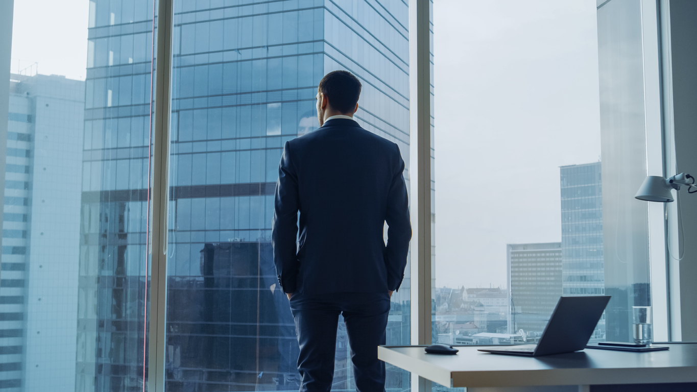 Thoughtful chief executive looking out of office window