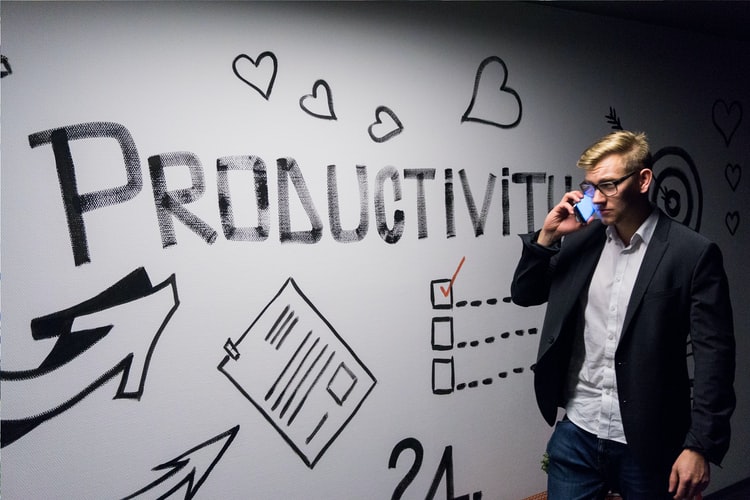 CEO standing in front of Productivity wall