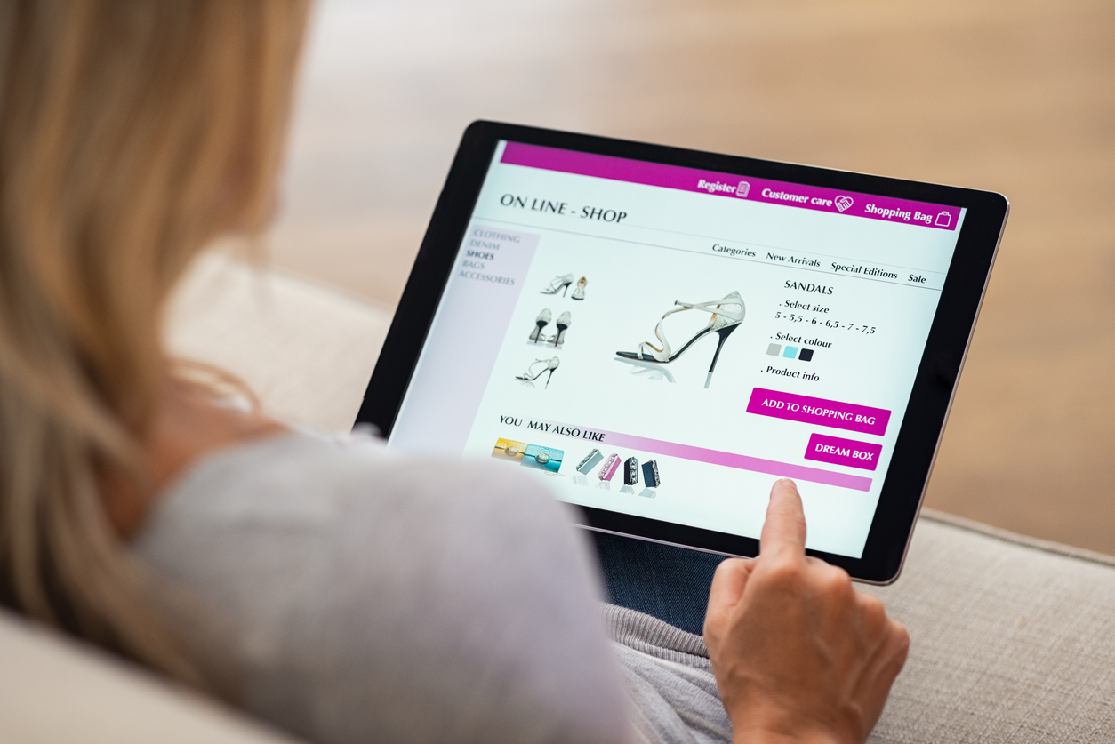 Woman shopping for sandals on a tablet