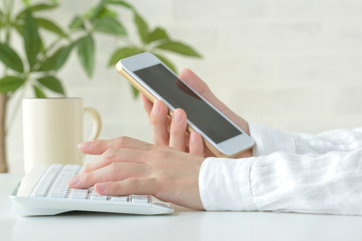 Person on laptop and phone working a side job