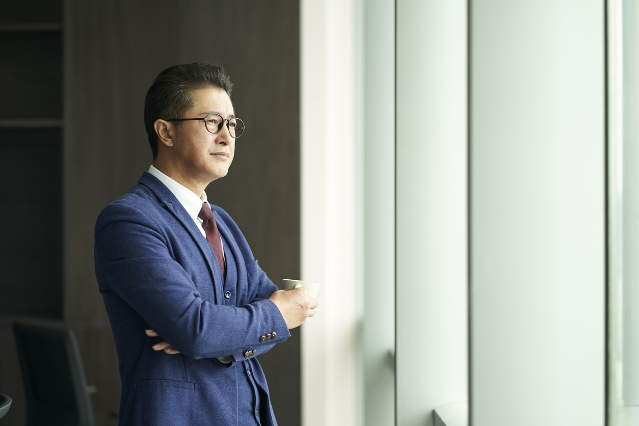 Businessman drinking coffee as he looks out the window