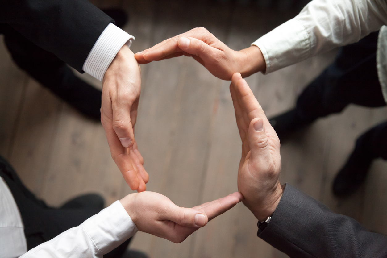 Business people join hands in circle, protection and support concept