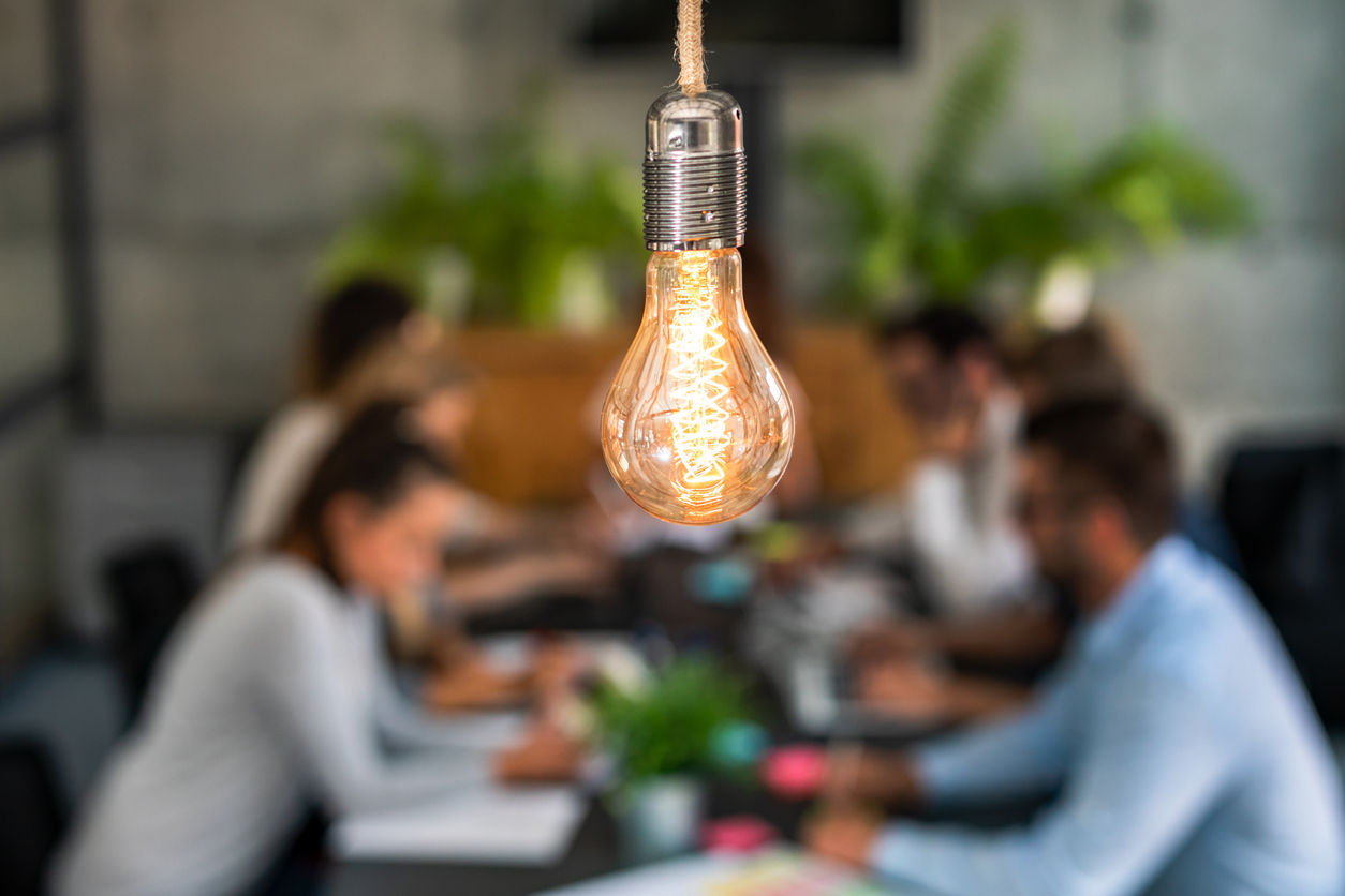 Business meeting under bright light bulb