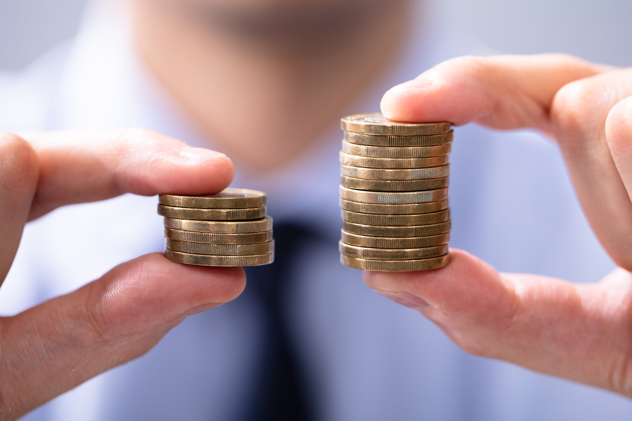 Man comparing two stacks of coins