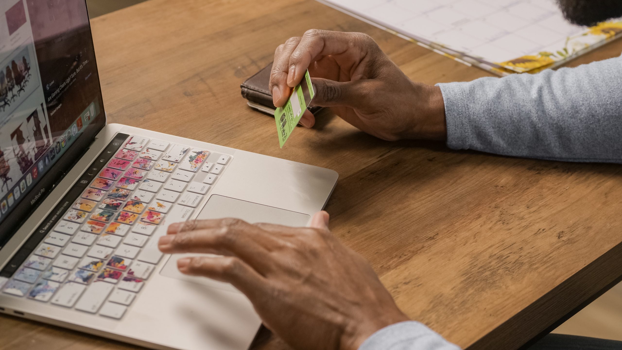 A businessman using a credit card to pay on their laptop