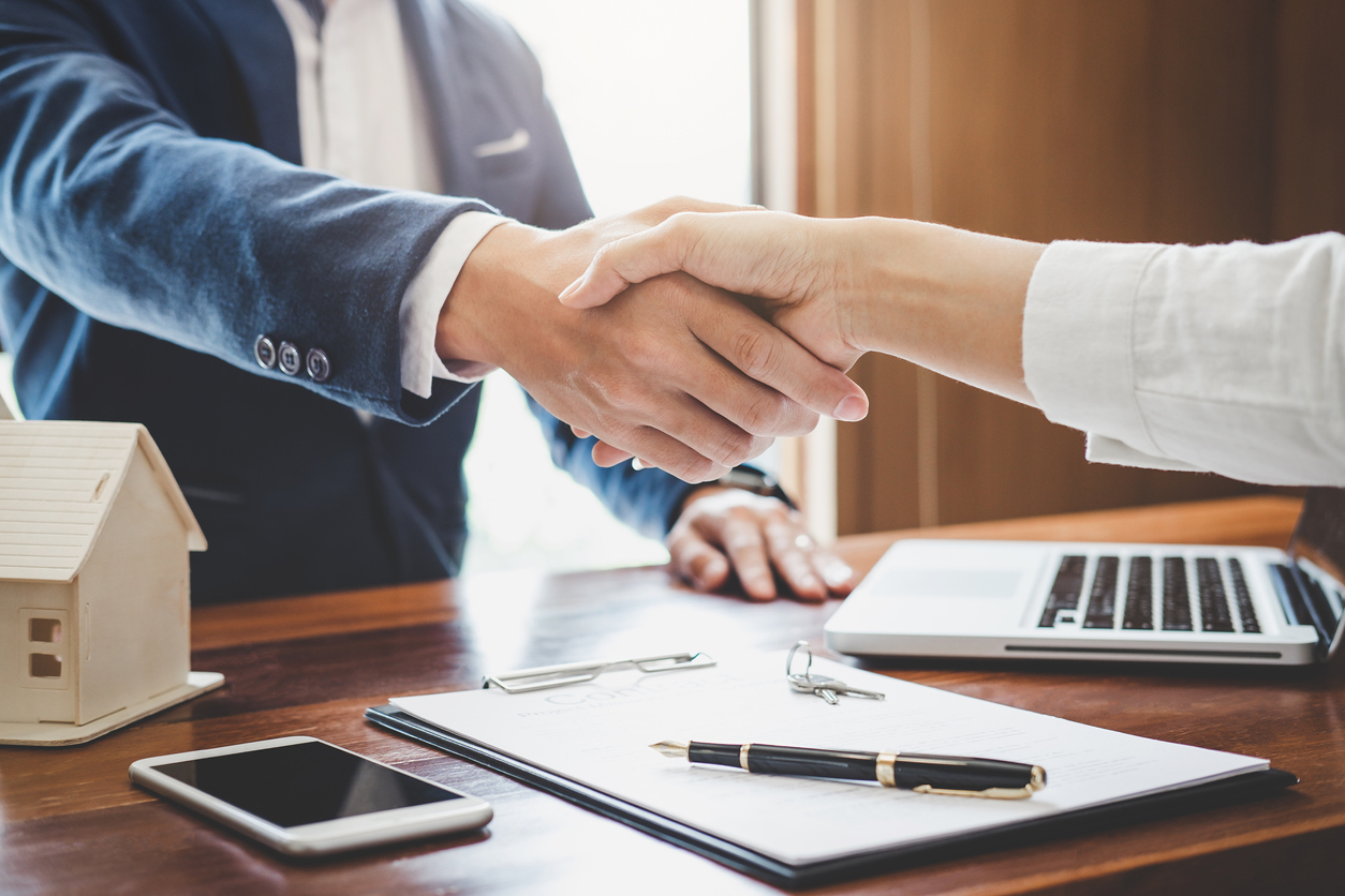 Real estate agent and customers shaking hands together celebrating finished contract after about home insurance and investment loan, handshake and successful deal.