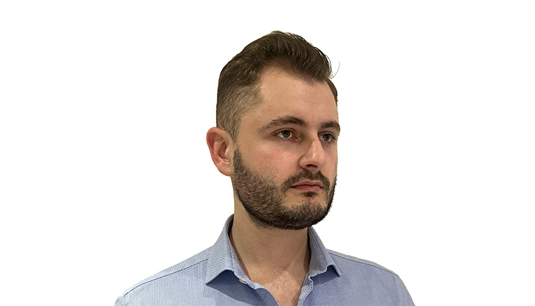 Nathaniel Fried standing in front of a white wall.