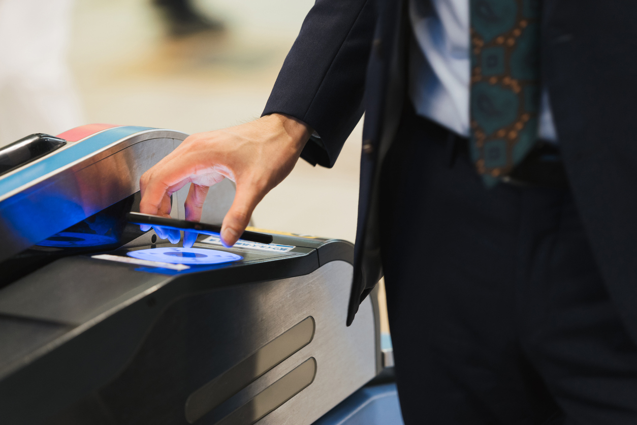 Businessmen passing through ticket gates with touchless technology (hands, ups, body parts)