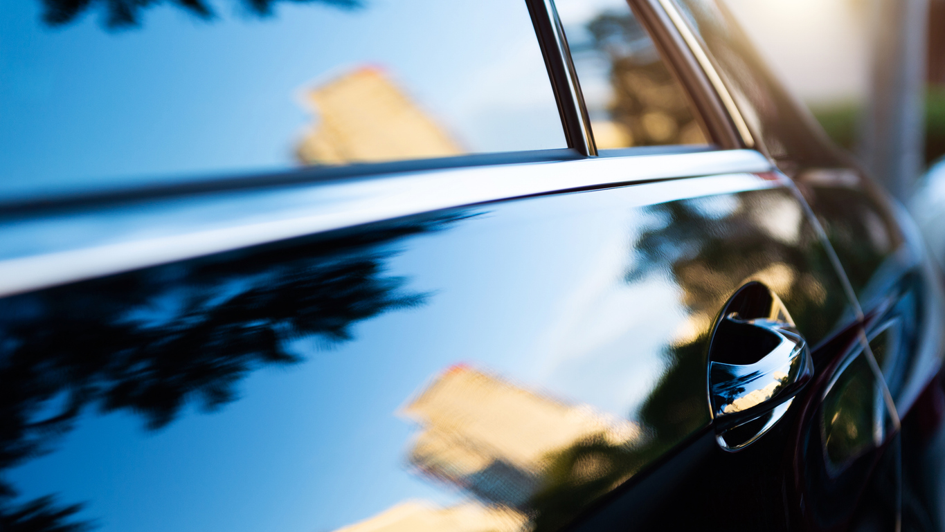 The sunset is reflected on black new car