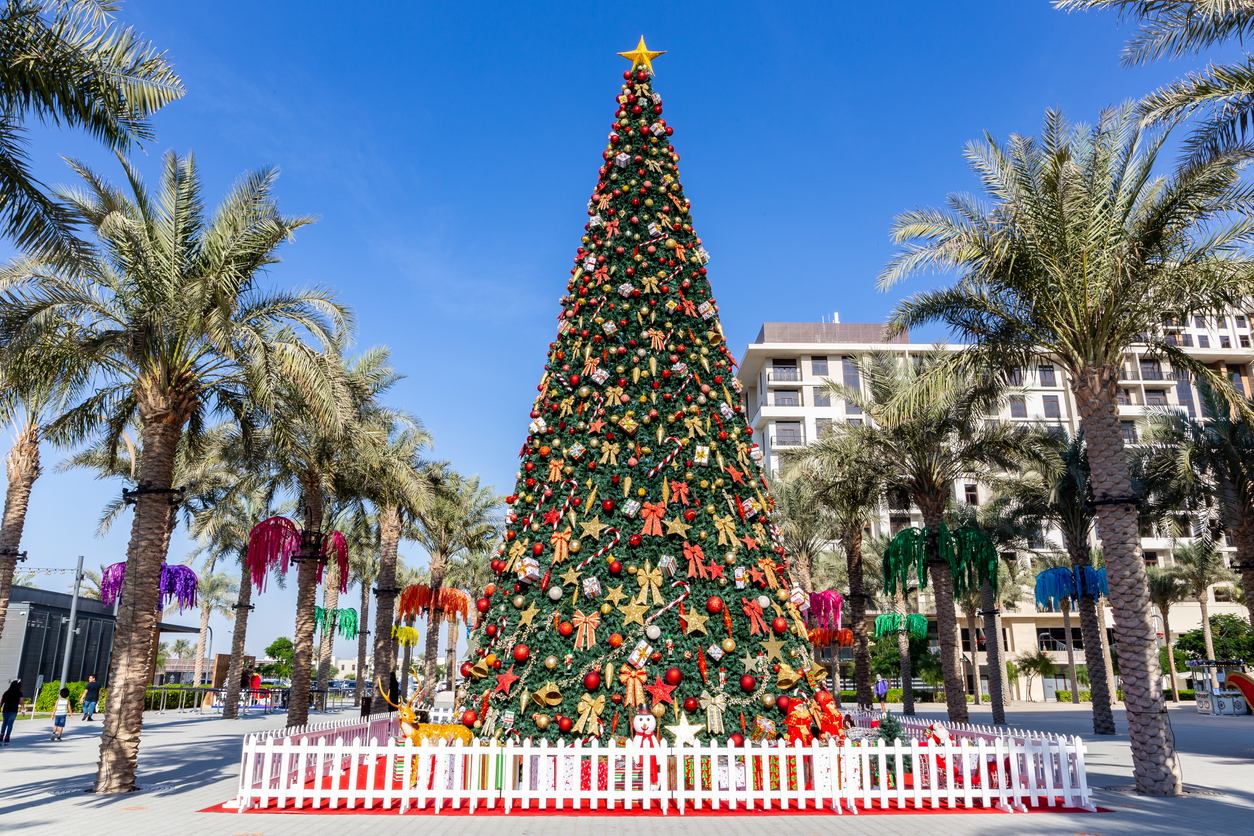 large christmas tree in dubai, town square park, 2020, amont green palm trees.