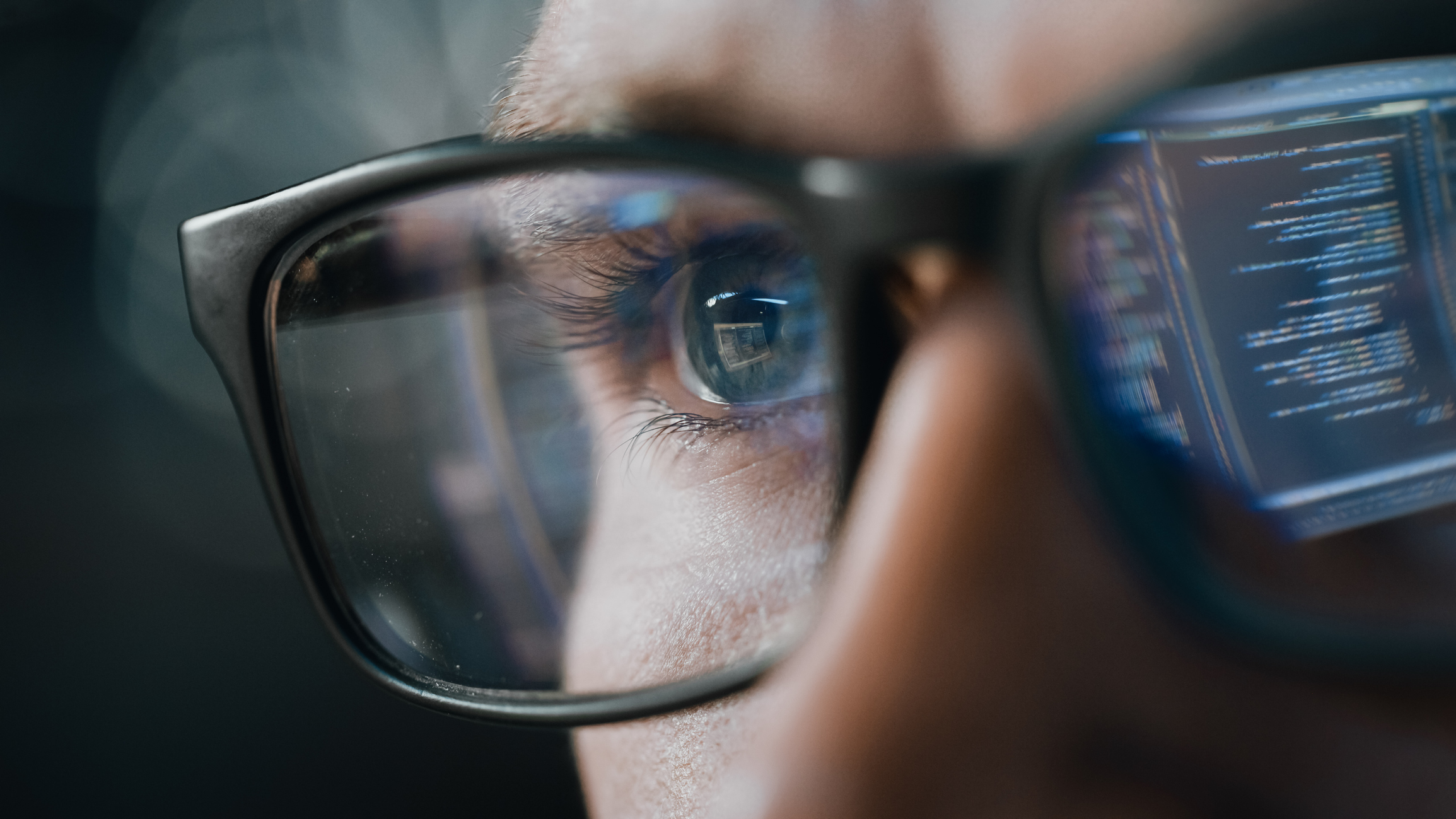 close up portrait of software engineer working on computer, line of code reflecting in glasses. developer working on innovative e commerce application using machine learning, ai algorithm, big data