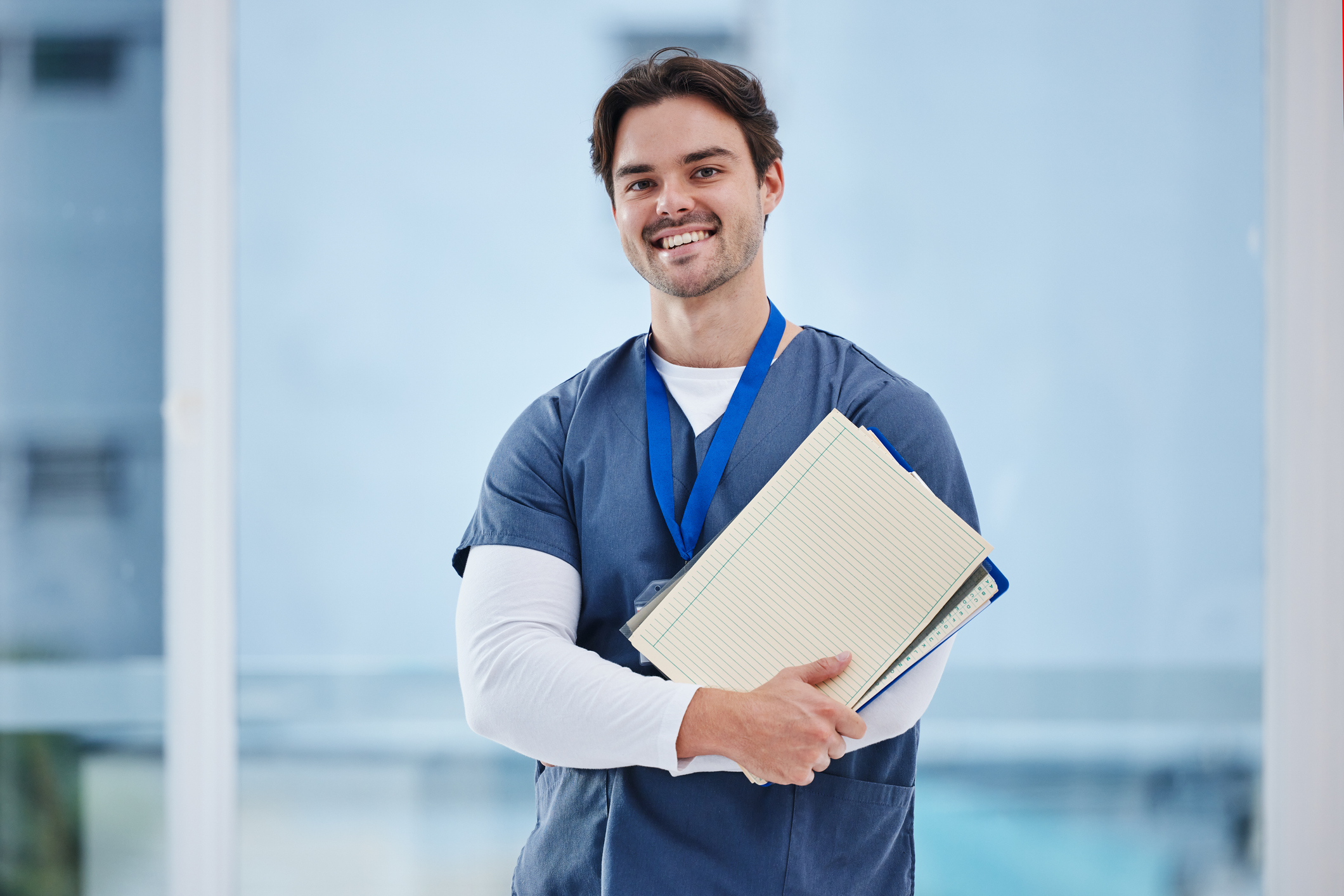 doctor, arms crossed and portrait of happy man with notebook, healthcare records or clinic info for study test. surgeon internship, medical education and student nurse confident for medicine research