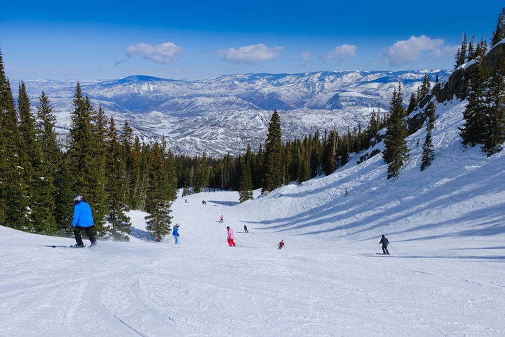 people skiing in colorado ski resort near aspen, colorado, on nice winter day