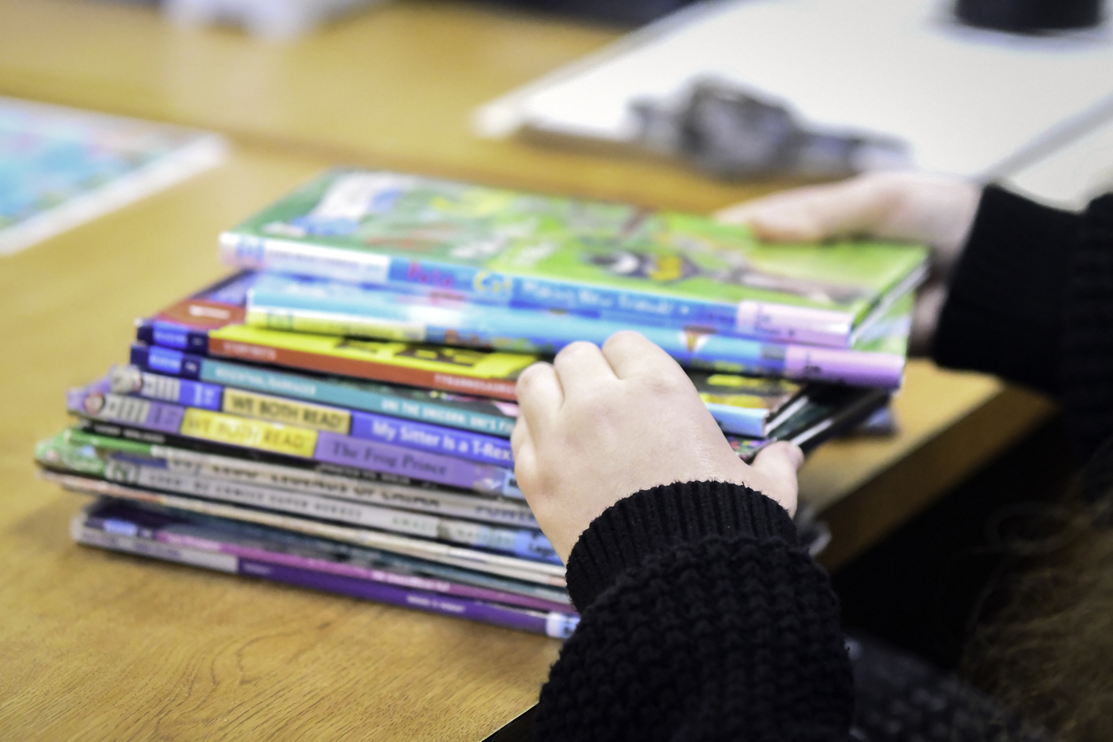 faceless portrait of librarian sorting children's books