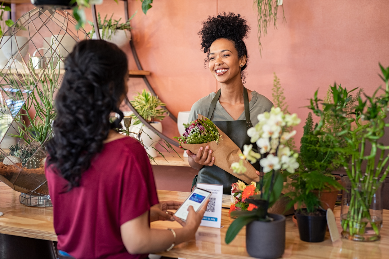 happy friendly florist giving fresh bouquet to customer