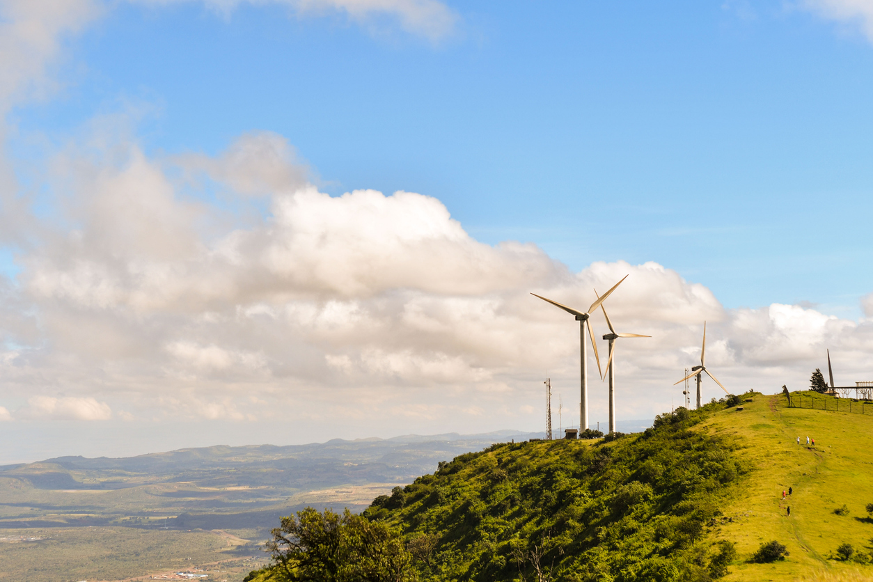 scenic view of landscape and wind turbines against sky