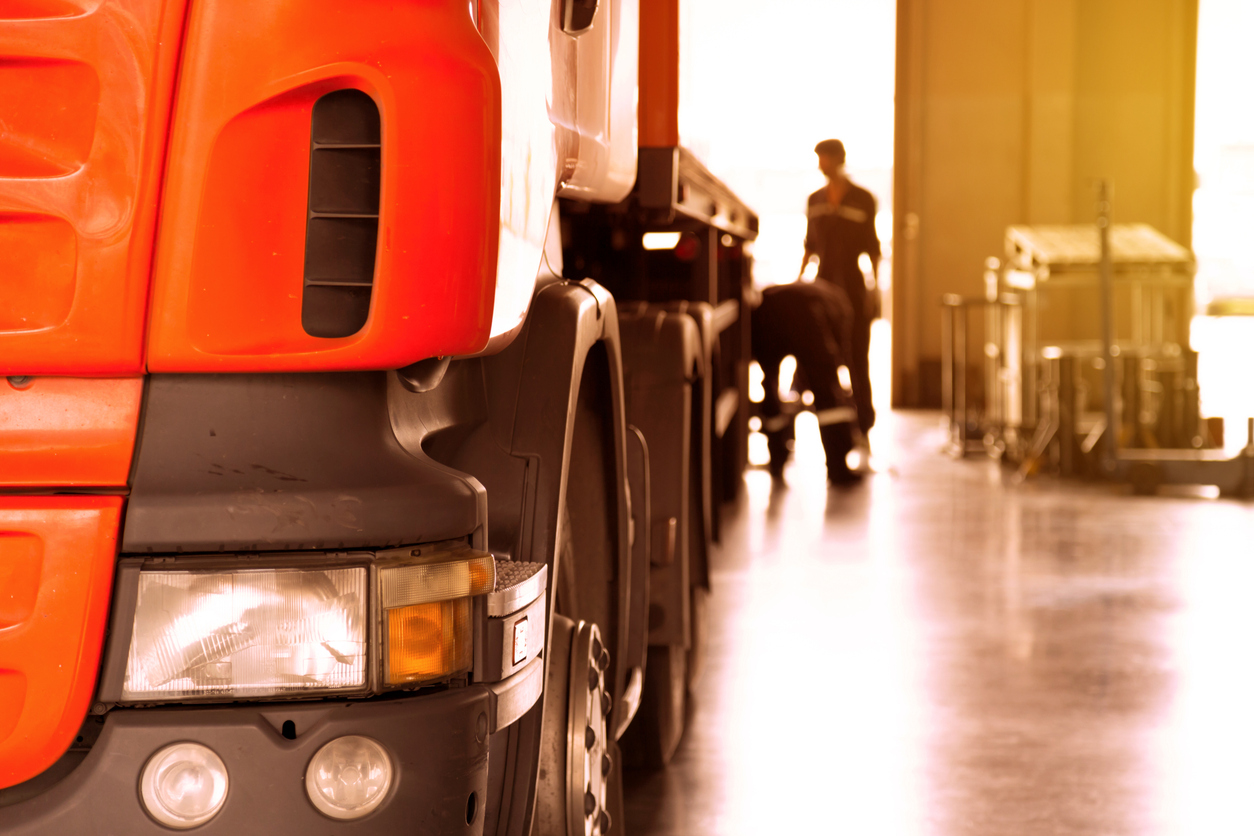 automobile mechanic checking truck in the garage with sunbeam, selective focus