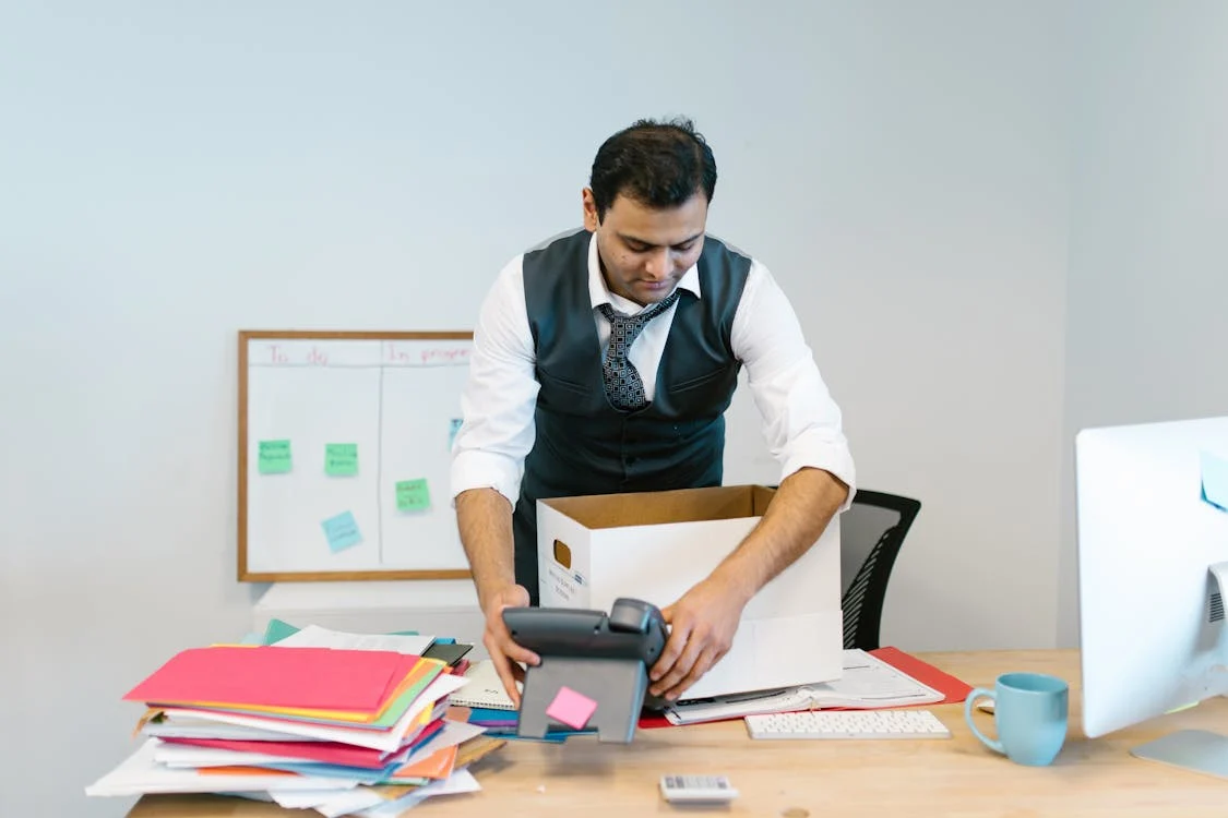 Man boxing up his office to significy a relocation of the office.